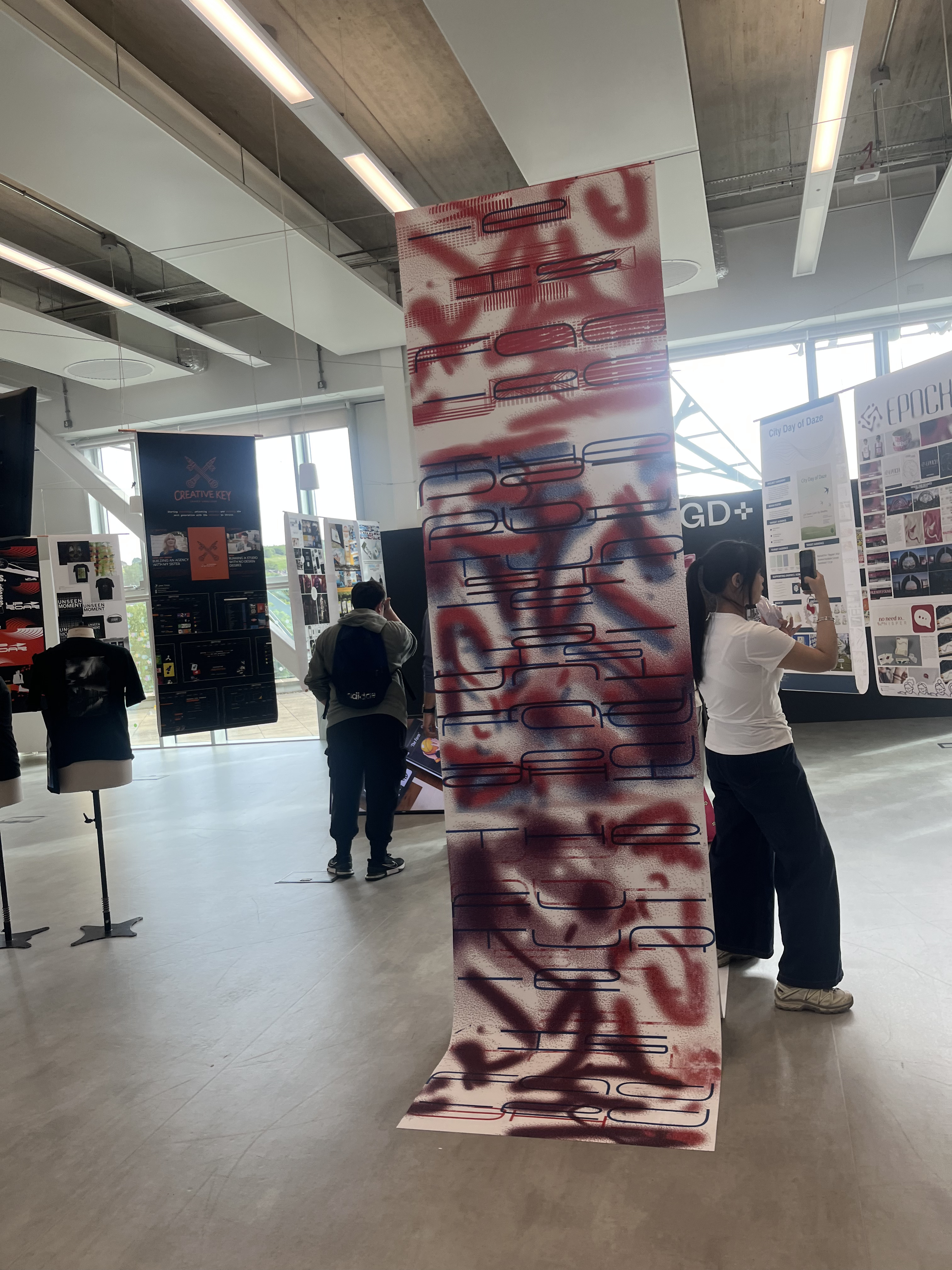 FADA installation — floor to ceiling poster with anaglyph type at grad show